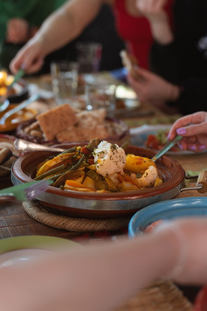 Moroccan cuisine tasting – sharing traditional Moroccan dishes in a cozy desert camp atmosphere.